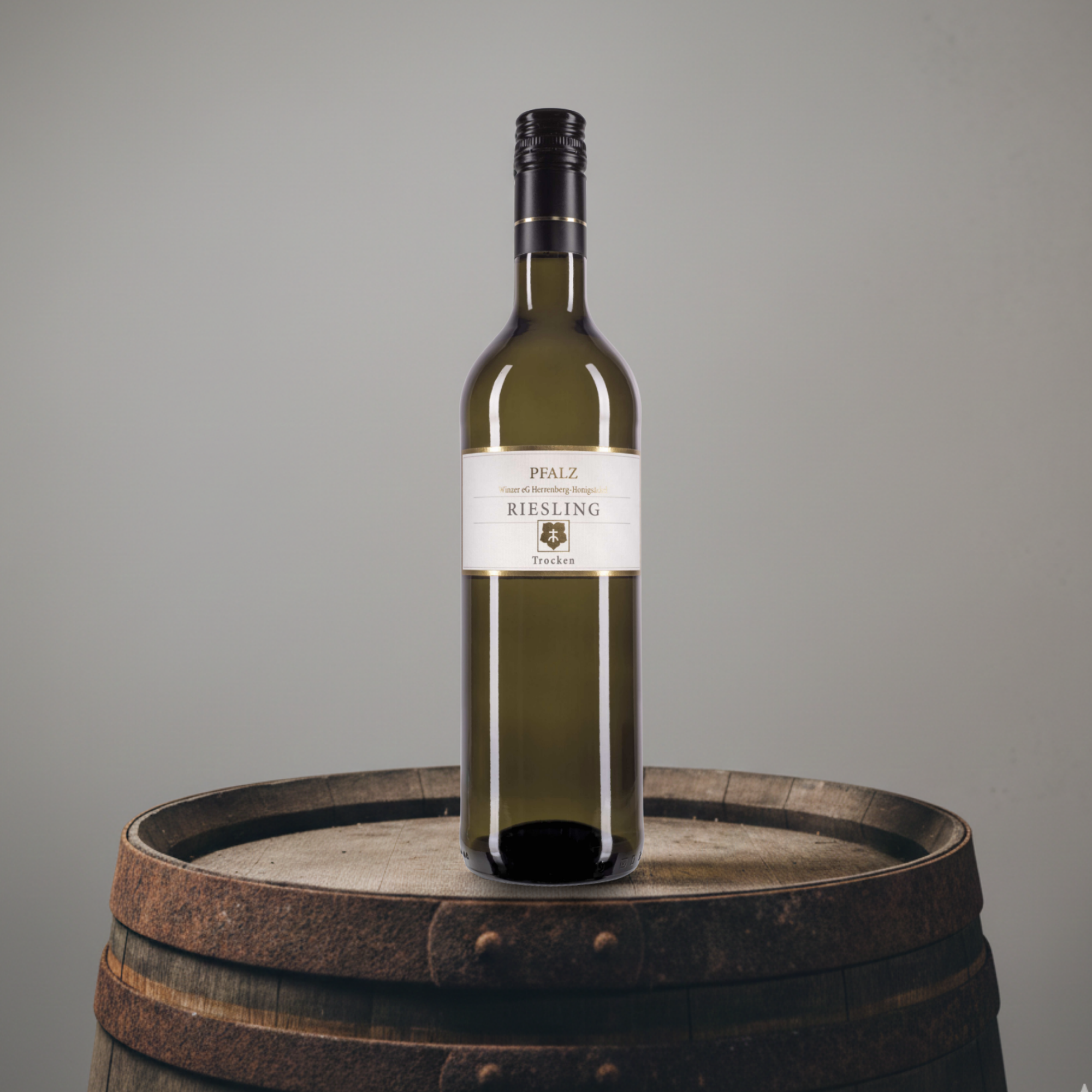 Wine bottle labeled 'Pfalz Riesling' on a wooden barrel with a gray background